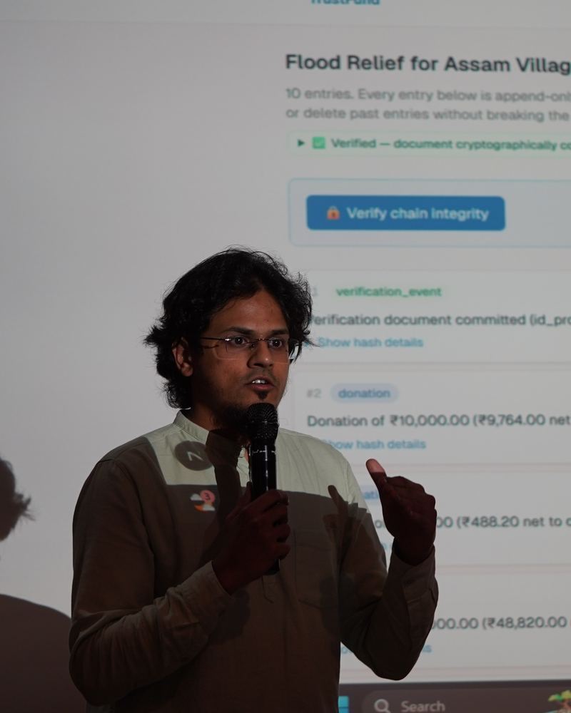 A builder presenting a public ledger for flood relief in Assam villages